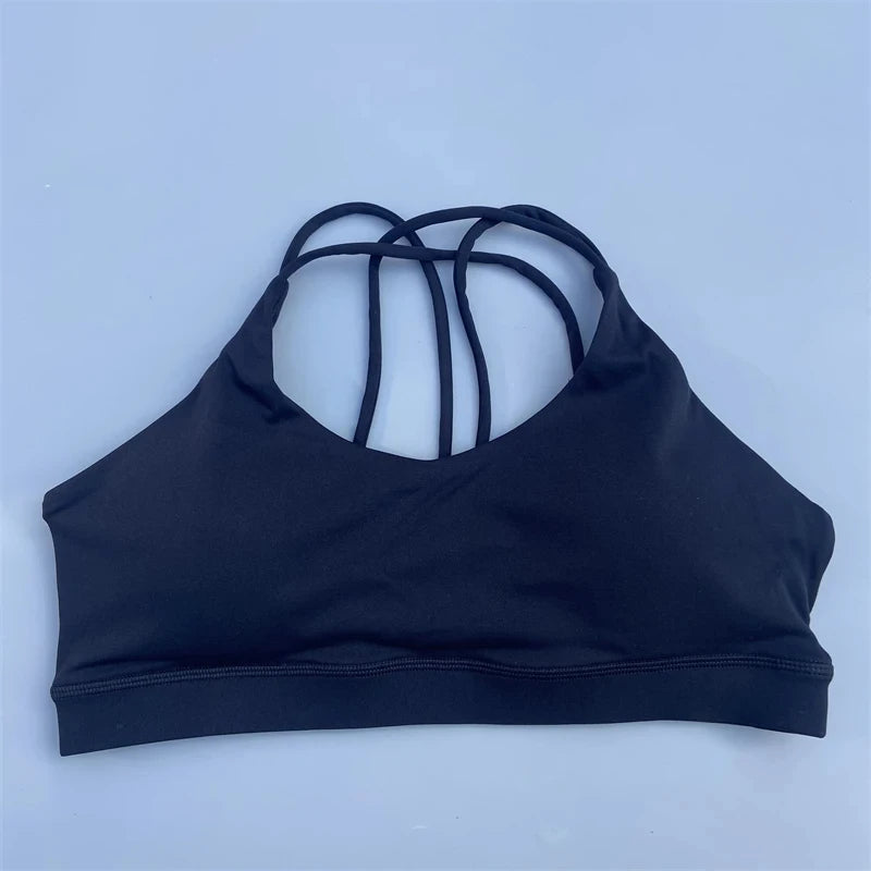 Black sports bra with thin straps on a light blue background