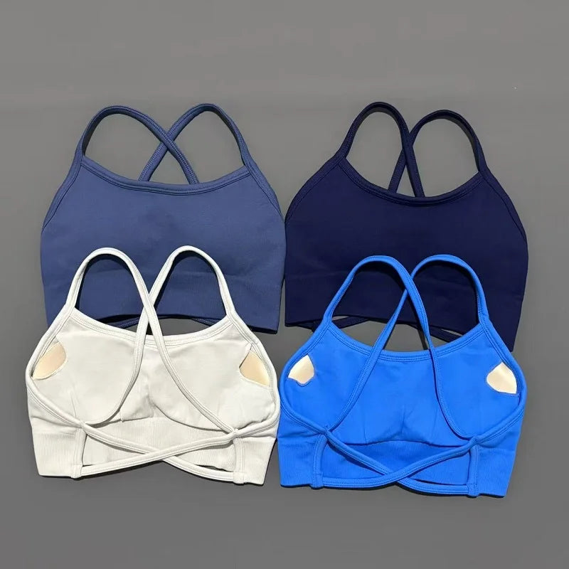 Four bras in blue, white, and navy on a gray background