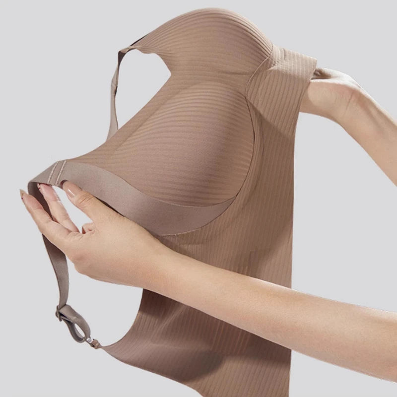 Beige bra held by a hand against a light gray background
