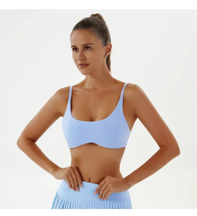 Woman wearing a light blue sports bra and leggings on a white background