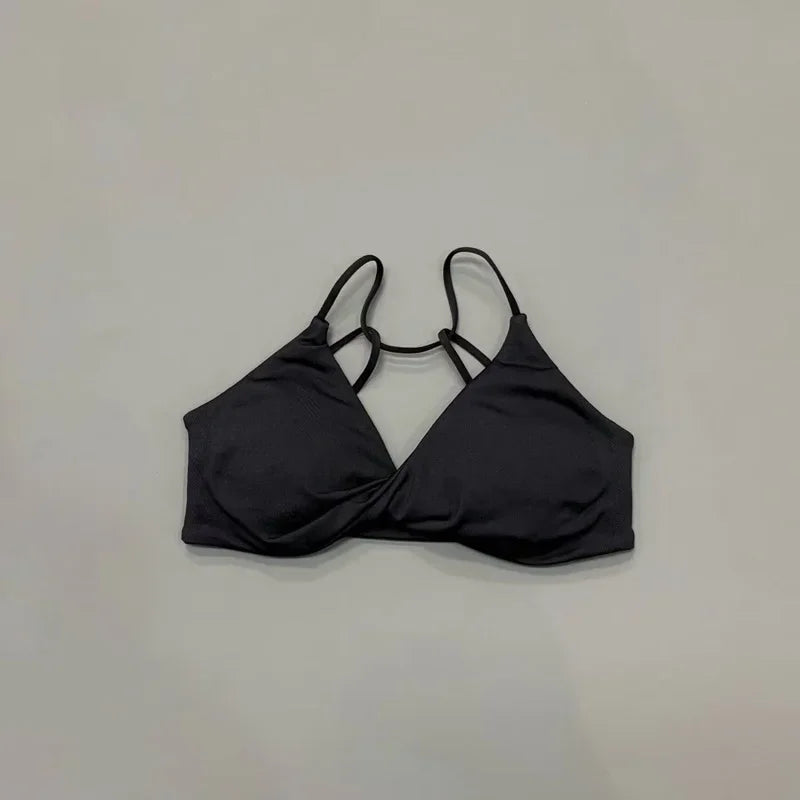 Black bikini top on a light gray background