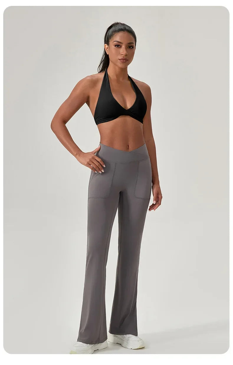 Woman wearing a black sports bra and gray leggings on a light gray background