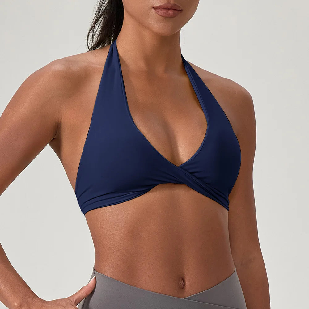 Woman wearing a navy blue bikini top against a plain background
