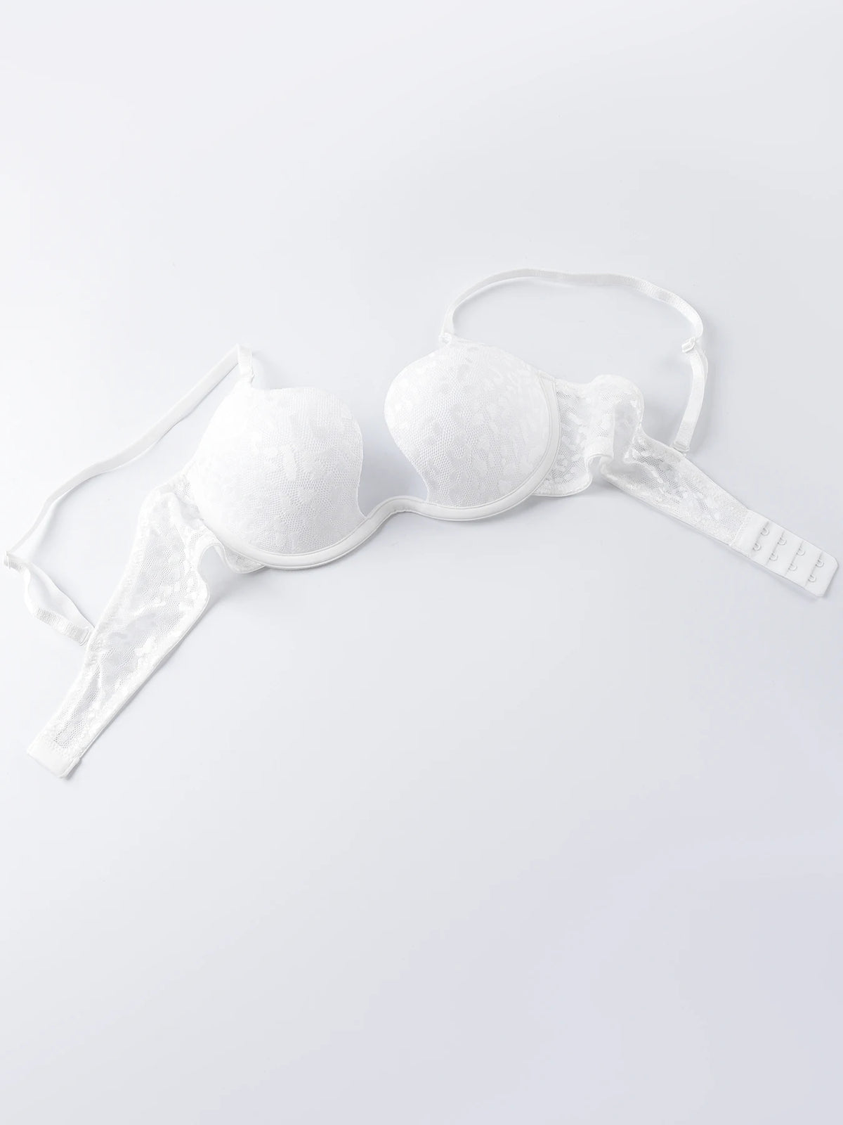 White lace underwire bra with padded cups and adjustable shoulder straps, laid flat on a light gray background.
