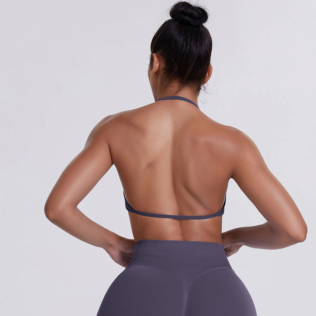 Person wearing a gray sports bra and leggings on a light gray background