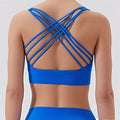 Blue sports bra with criss-cross straps on a plain background
