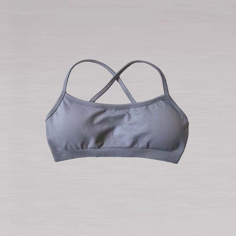 A gray sports bra with thin crisscrossing straps, shown against a light gray background.