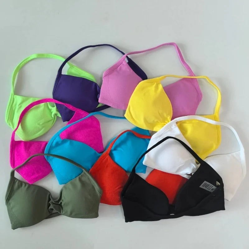 A collection of colorful triangle bikini tops arranged on a light gray background, including green, purple, pink, yellow, blue, red, white, and black.