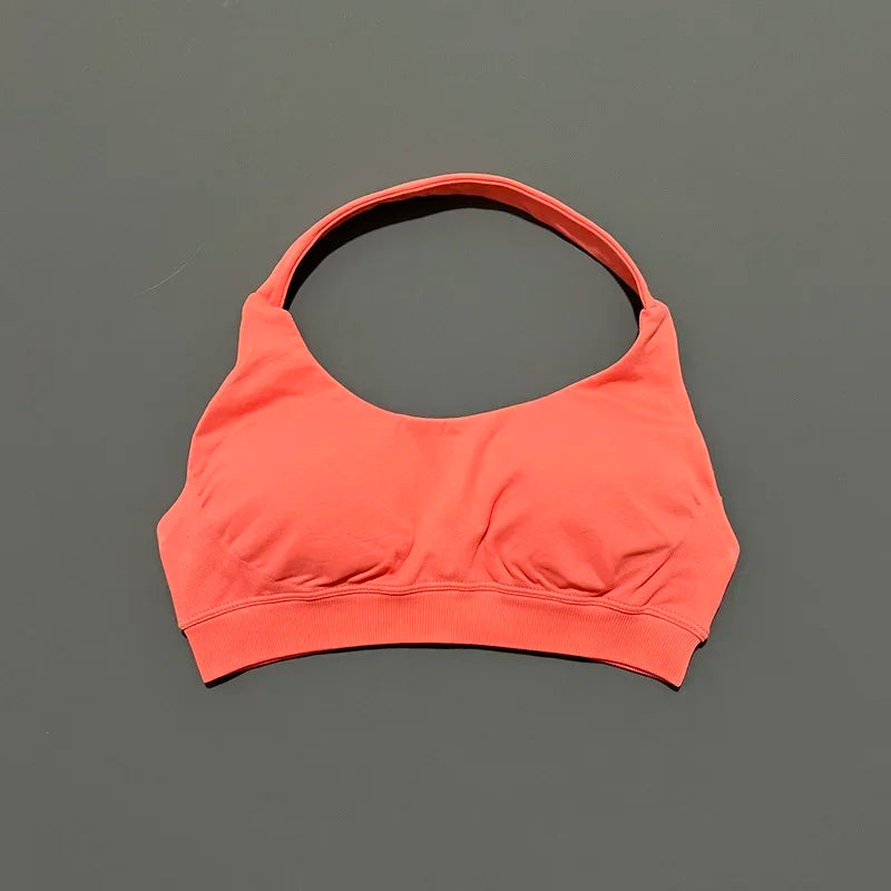 Coral sports bra on a gray background
