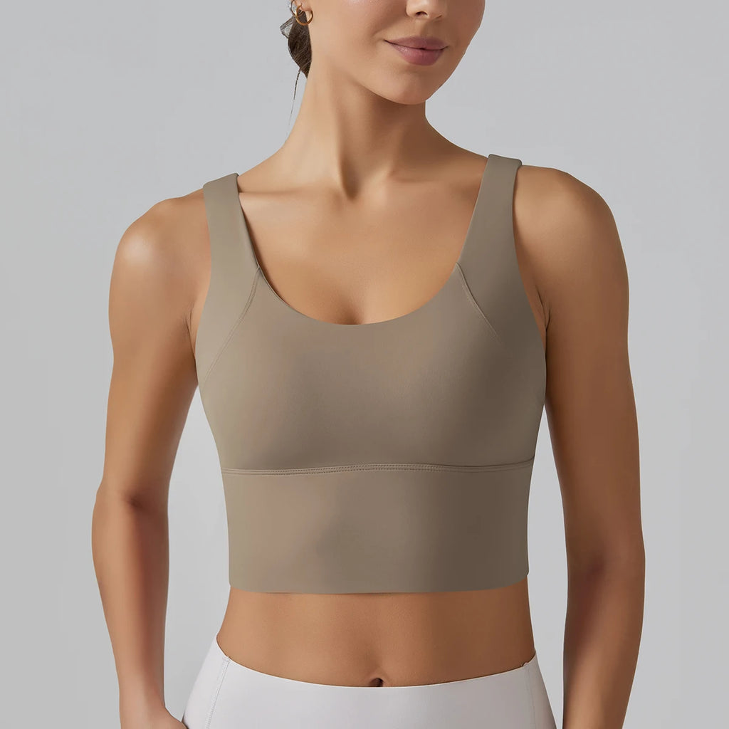 Woman wearing a beige sports bra against a gray background