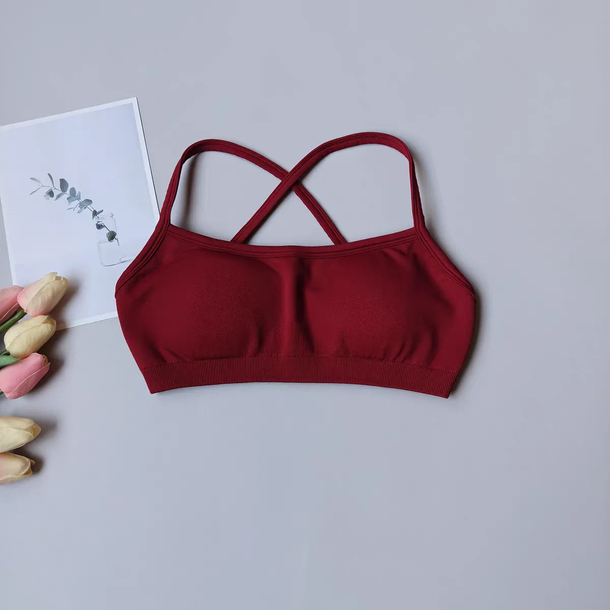 Red bralette on a light gray background with tulips and a card.