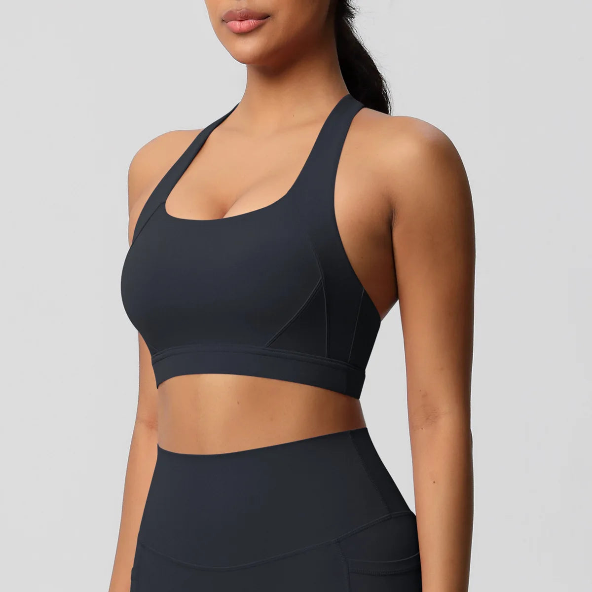Black sports bra worn by a person on a gray background
