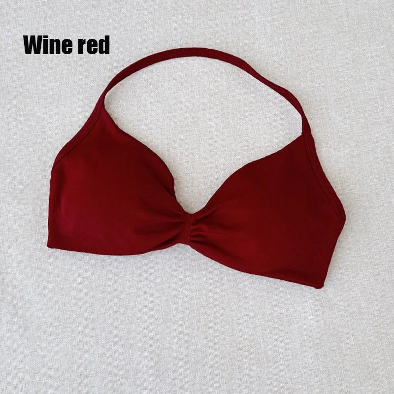 A wine red halter bikini top with a twisted front detail, laid flat on a light beige textured fabric background. The text 'Wine red' is printed in black in the top-left corner.