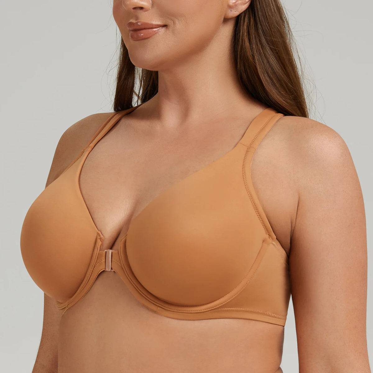Woman wearing a brown bra against a neutral background