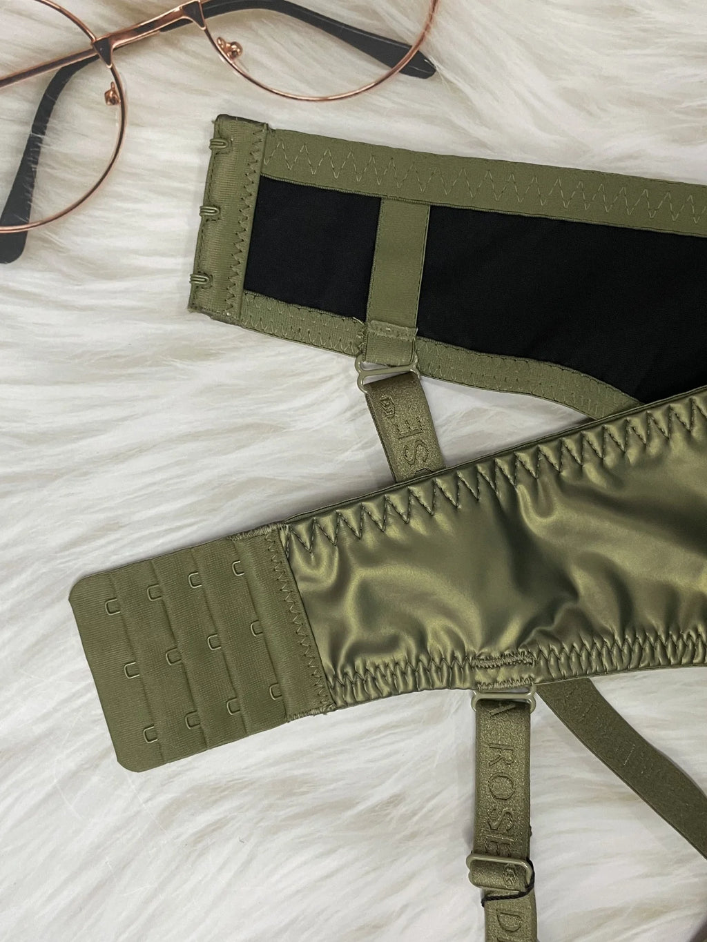 Green bra with straps on a textured white surface