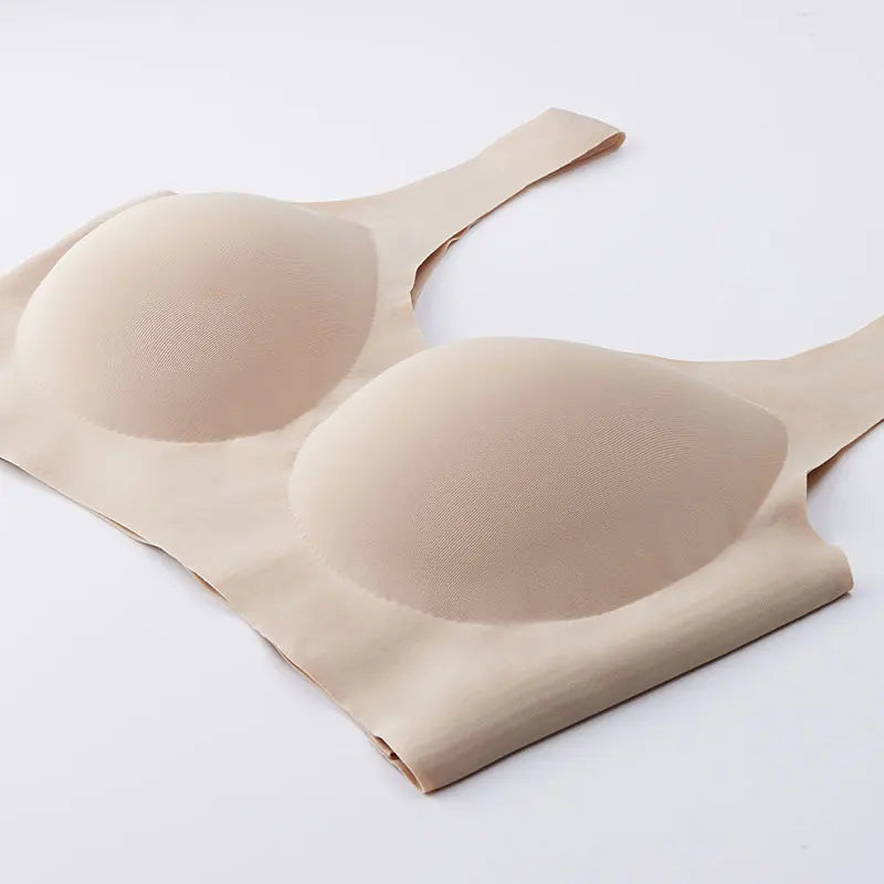 A beige seamless wireless bra with molded cups and wide shoulder straps, shown flat on a clean white background.
