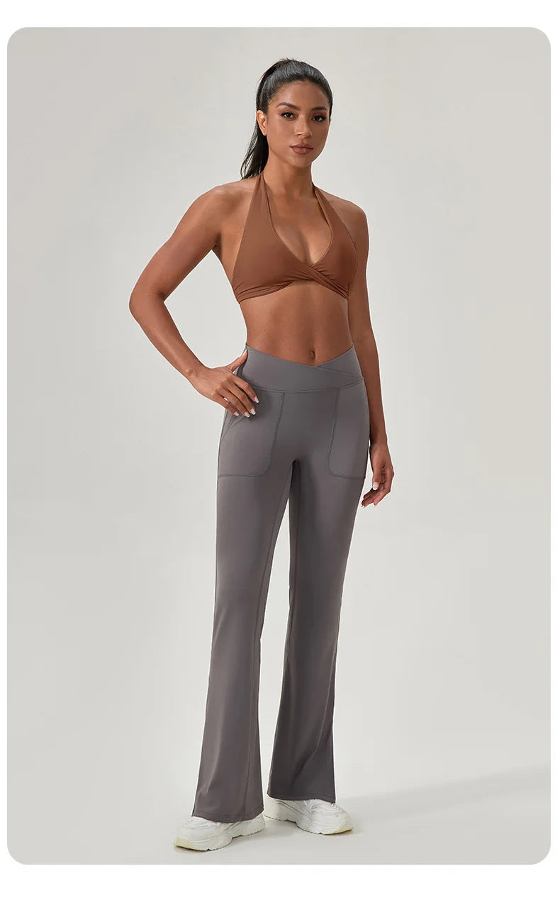Woman wearing a brown sports bra and gray leggings on a light gray background