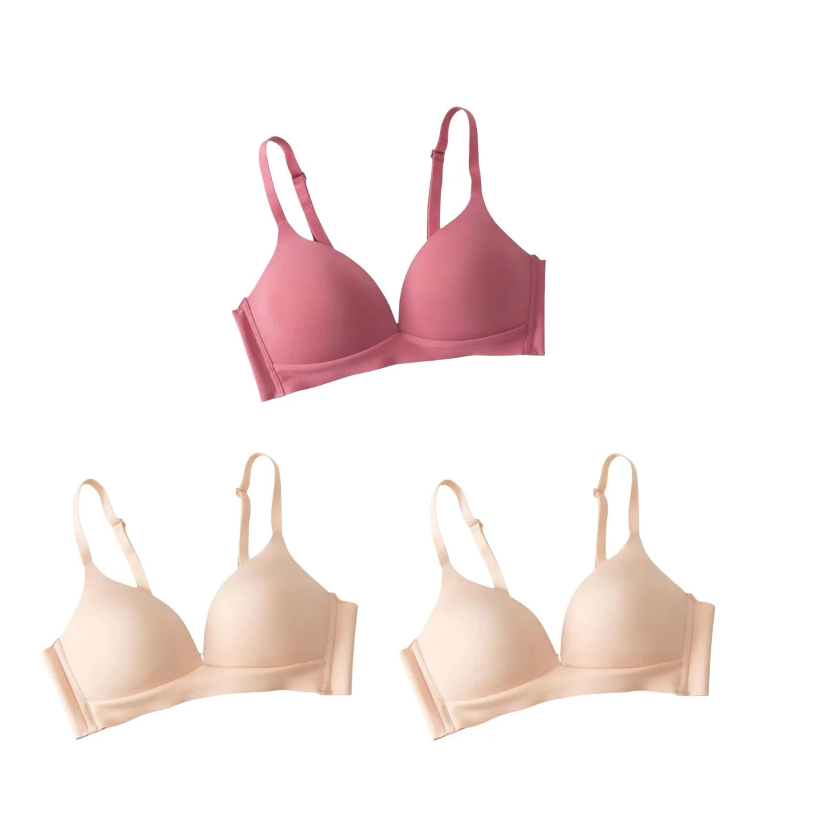 Set of three bras in pink and beige on a white background