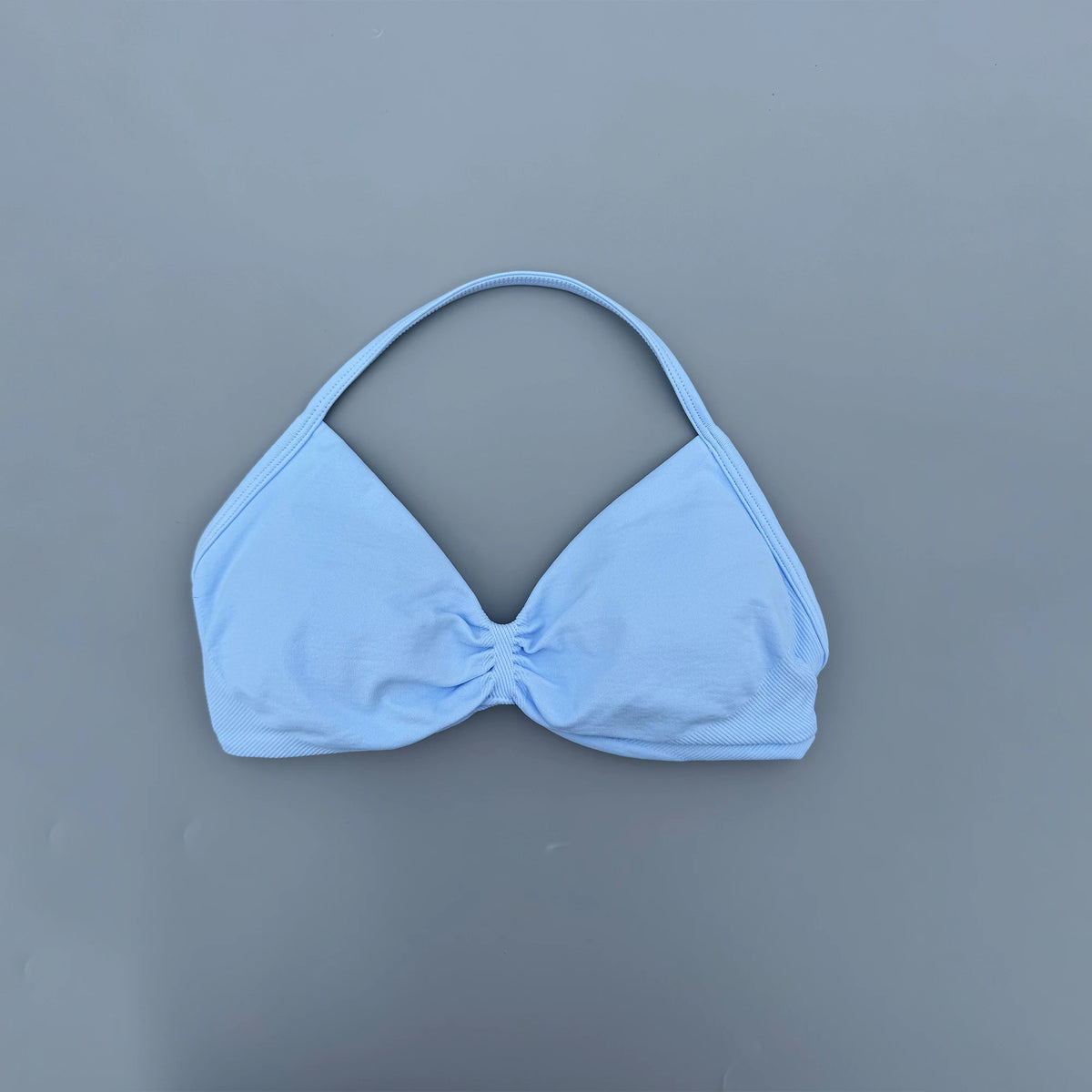 Light blue bikini top on a gray background