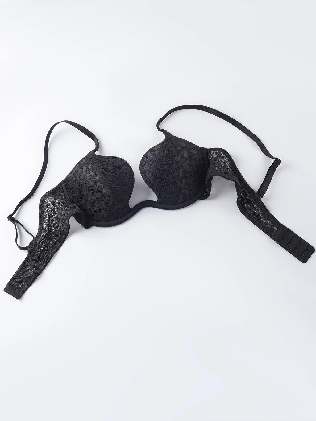 Black lace underwire bra with asymmetrical strap design, laid flat on a white background.