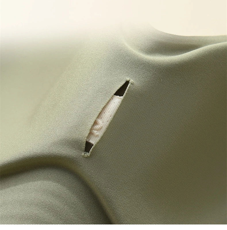 Close-up of a green fabric with a small tear.