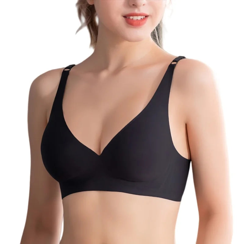 A woman wearing a black wireless bra with a deep V-neckline and wide shoulder straps, shown from the chest up against a plain white background.