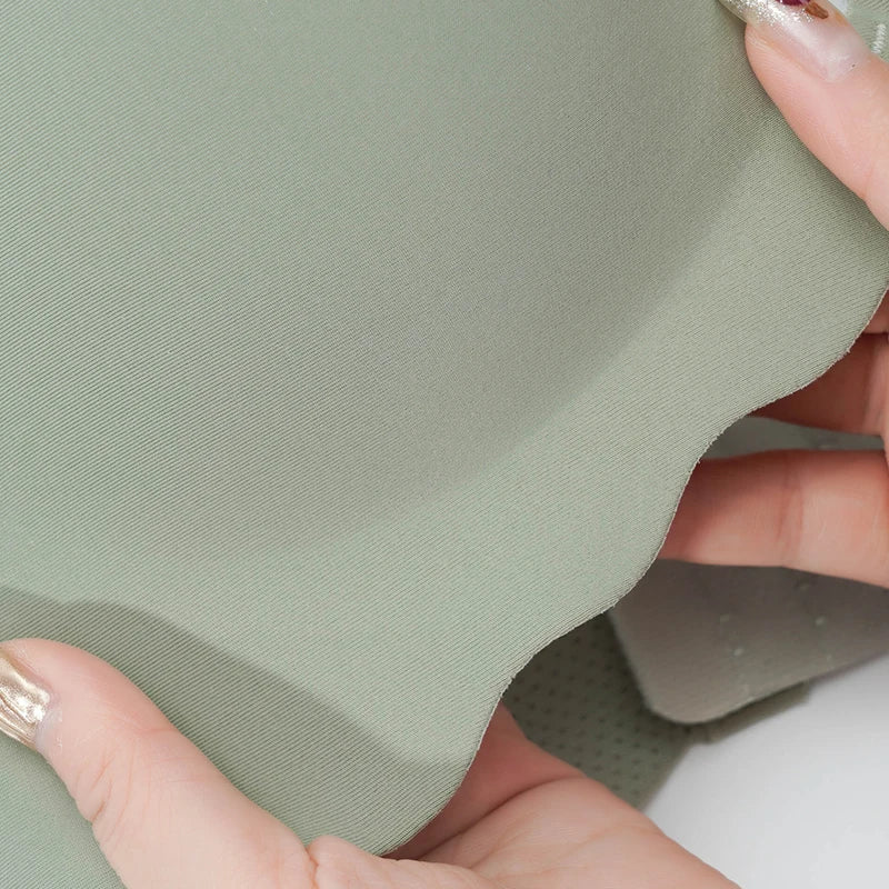 Person holding a piece of green fabric