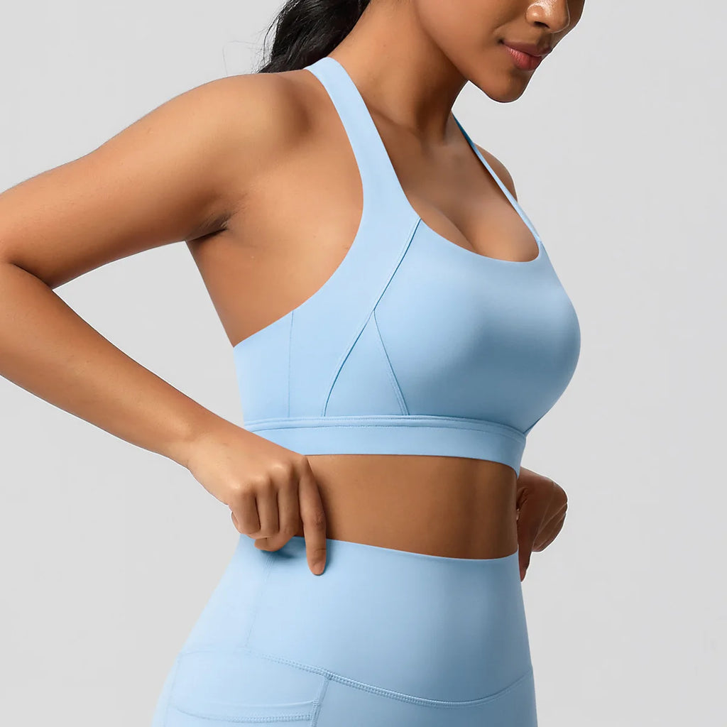 Woman wearing a light blue sports bra and leggings on a gray background