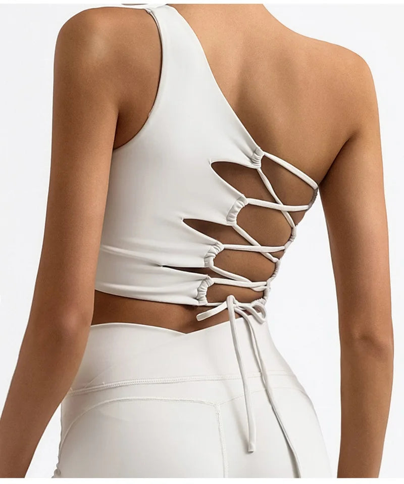 White sleeveless top with lace-up back design on a neutral background