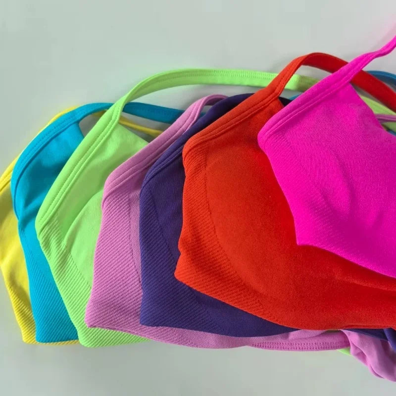 A set of colorful ribbed knit bikini cups or bralette tops fanned out on a plain light background. The visible colors include yellow, turquoise, lime green, lavender, purple, orange-red, and bright pink.