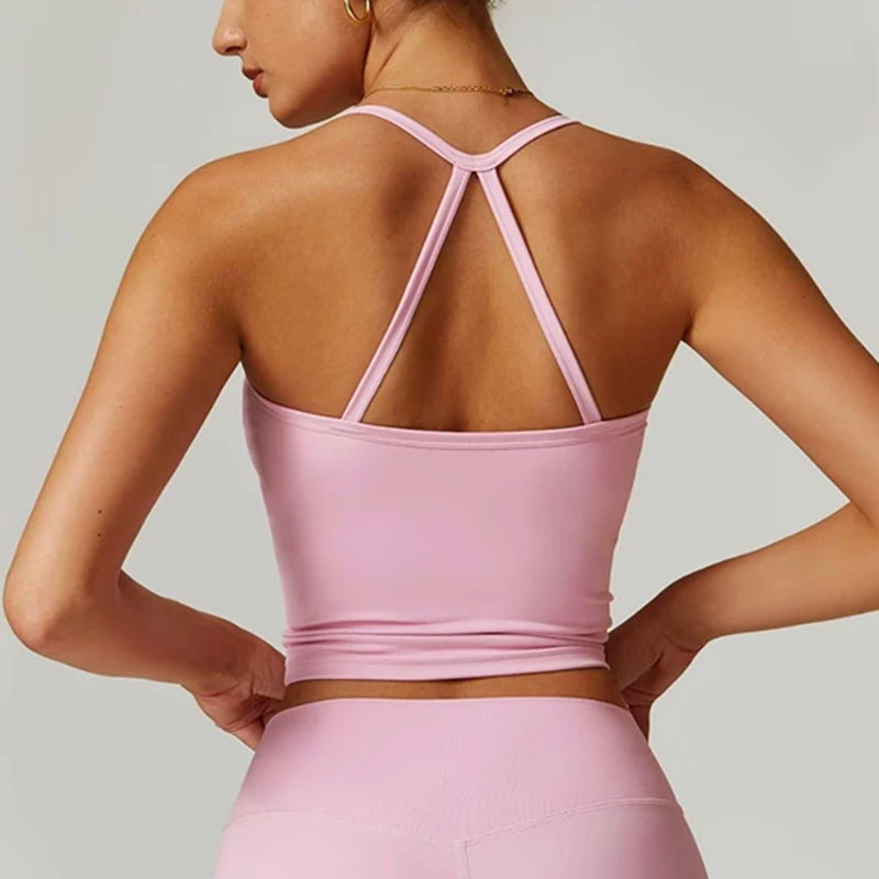 Person wearing a pink sports bra and leggings on a plain background
