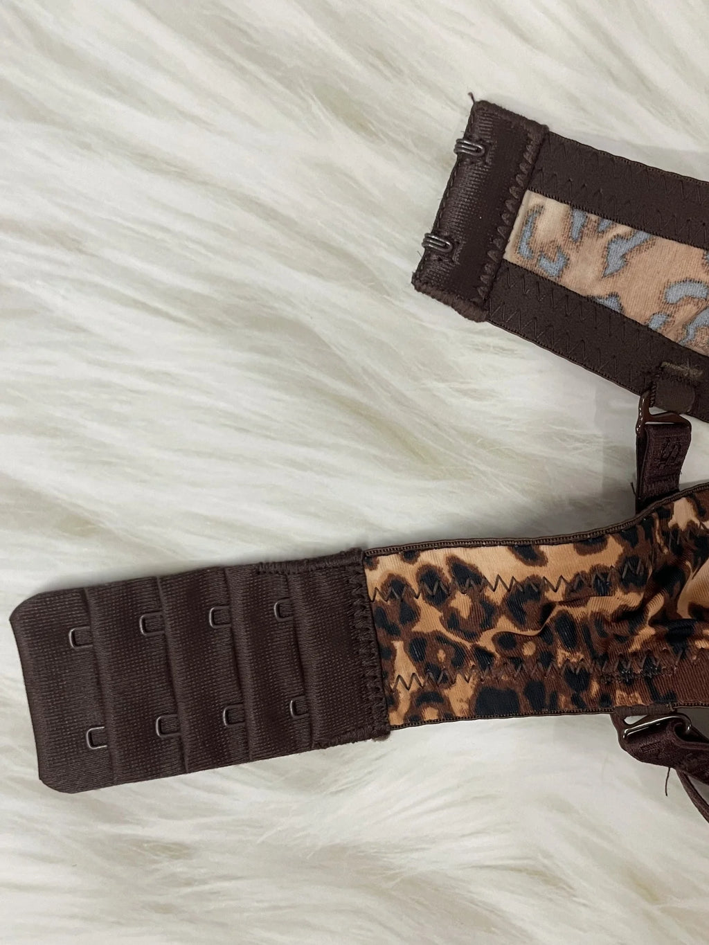 Leopard print and brown straps on a white fur background