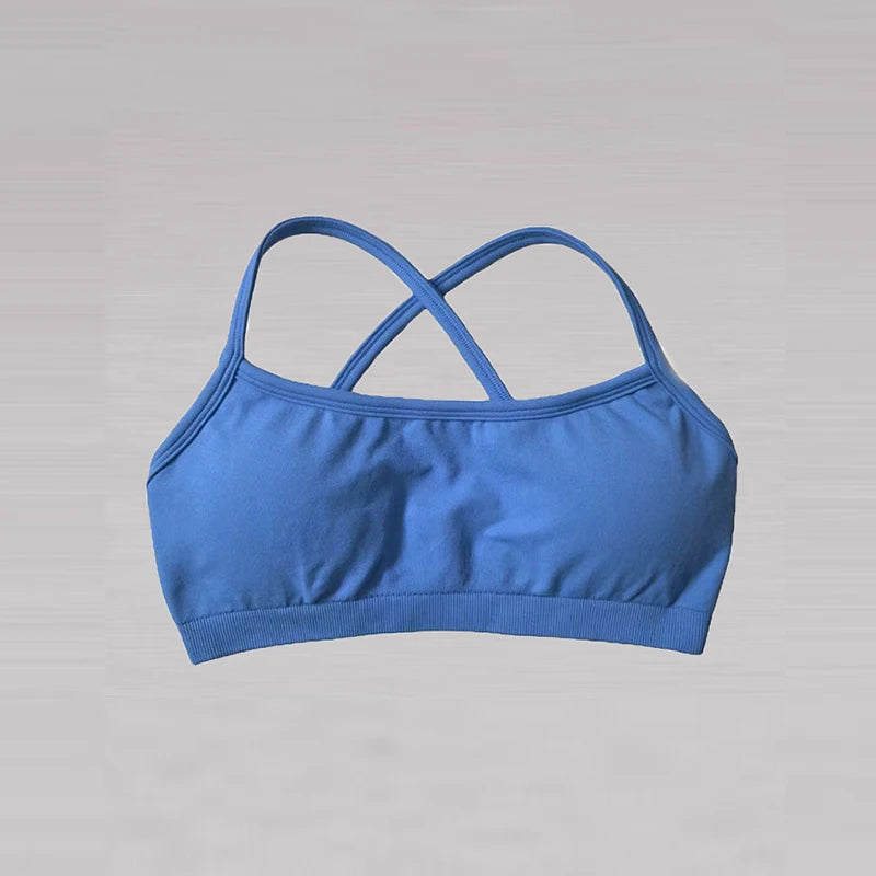 Blue sports bra with criss-cross straps on a gray background