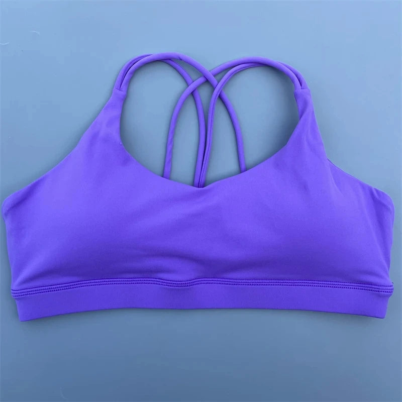 Purple sports bra with thin straps on a light blue background