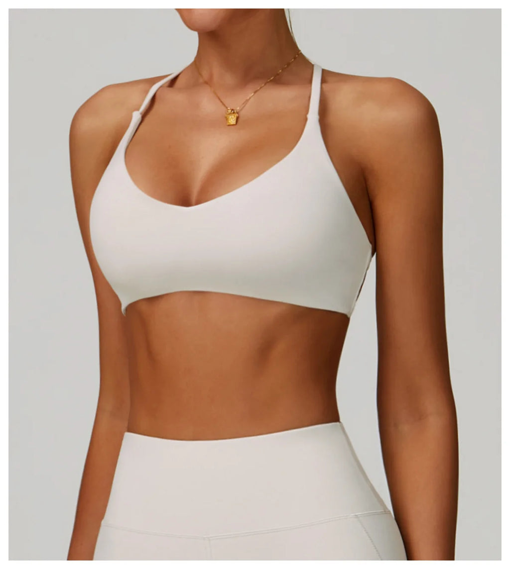 Person wearing a white sports bra and leggings on a plain background