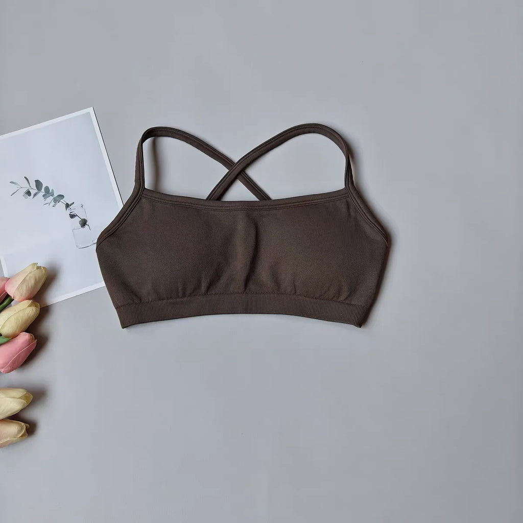 Brown bralette on a gray surface with tulips and a card in the background
