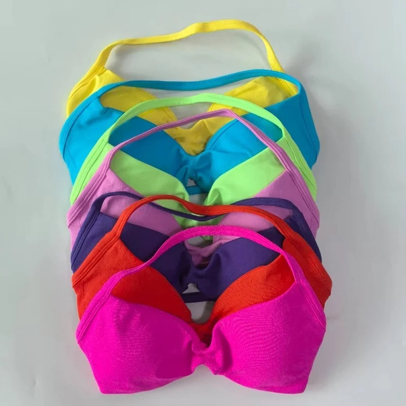 Stack of colorful bras on a light gray background