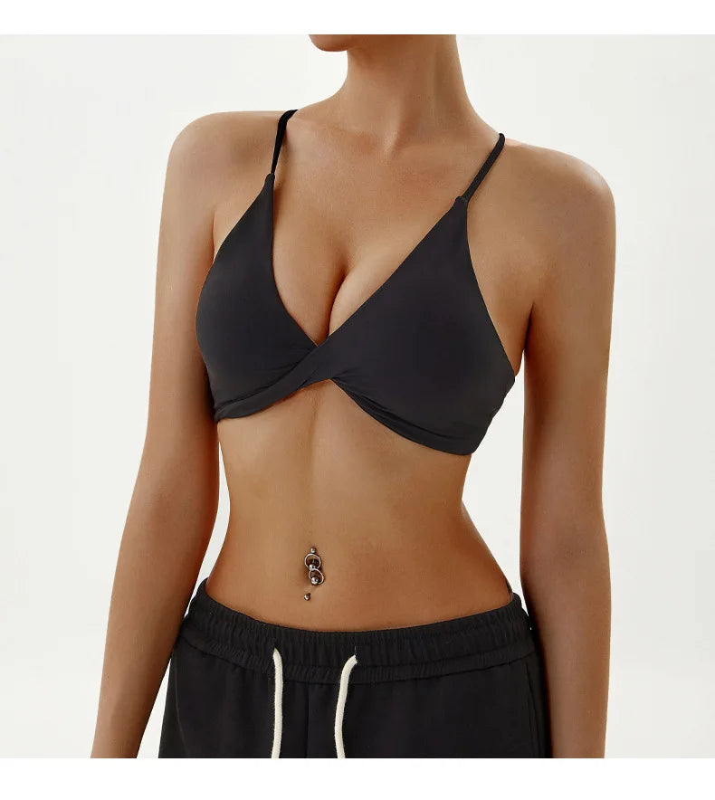 Person wearing a black bra and black pants on a white background