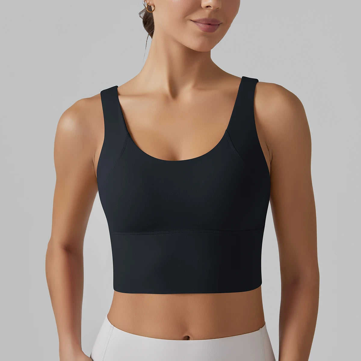 Black sports bra worn by a person on a gray background