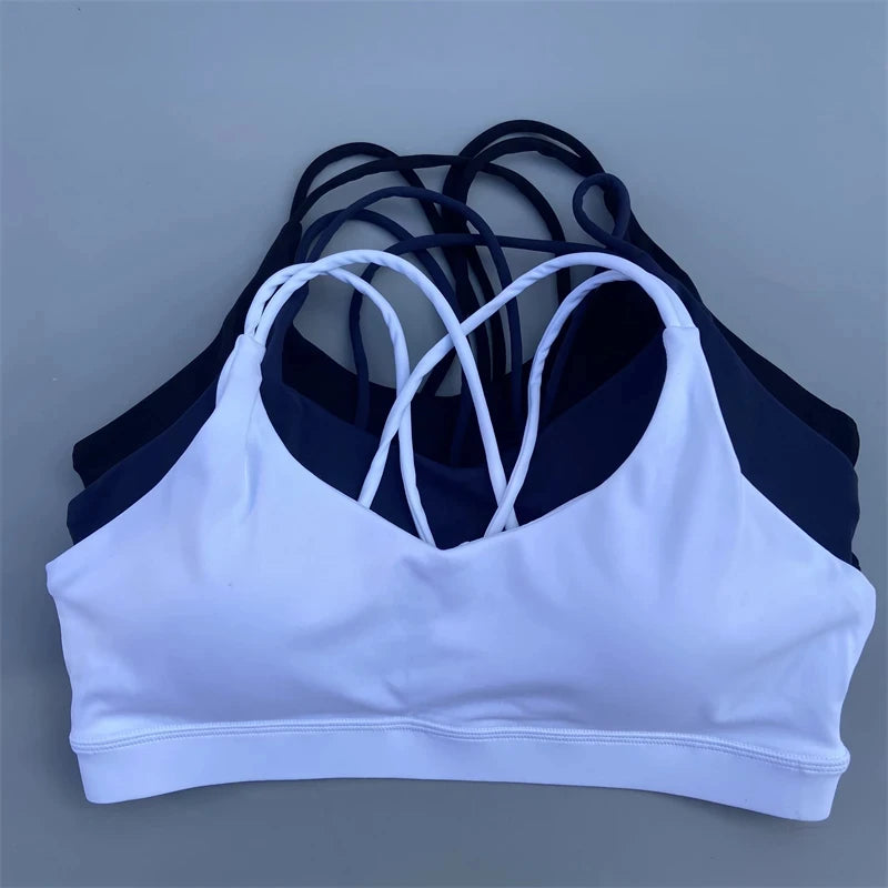 White and navy sports bras on a gray background