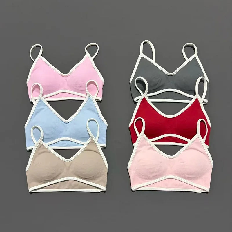 Set of five bras in various colors on a gray background