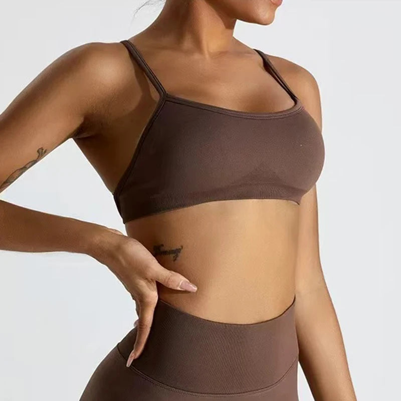 Person wearing a brown sports bra and leggings on a plain background