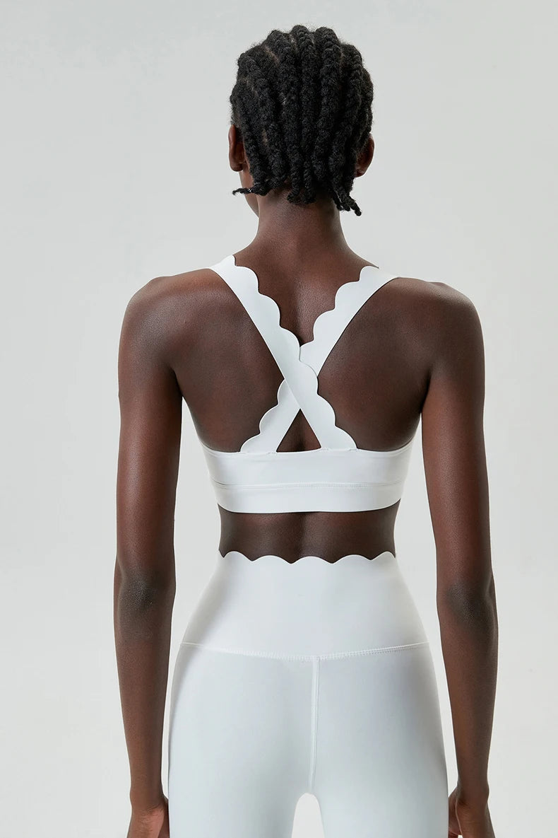 Person wearing a white sports bra and leggings set on a plain background