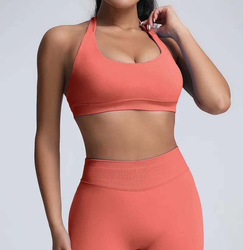 Person wearing a coral sports bra and leggings set on a light gray background