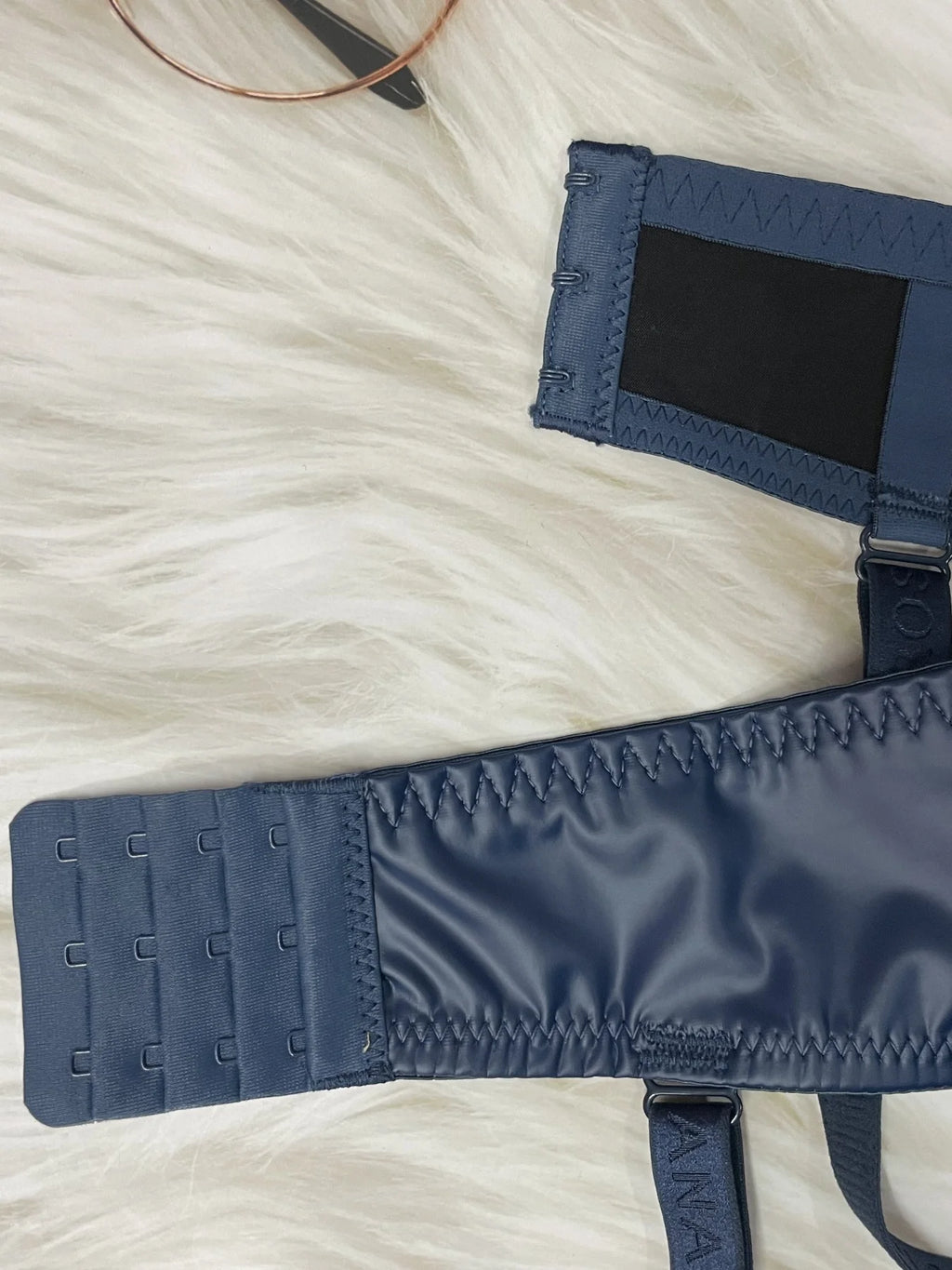 Navy blue belt with a strap on a white textured surface