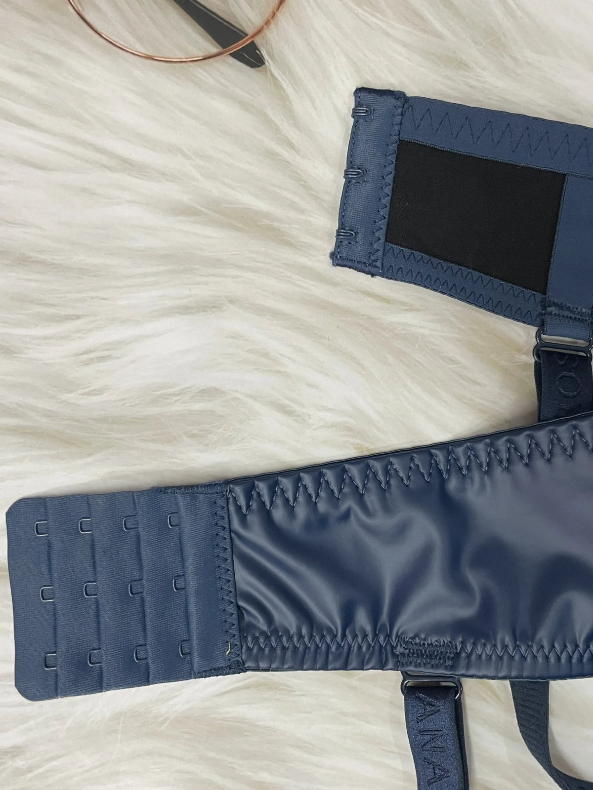Navy blue belt with a strap on a white textured surface