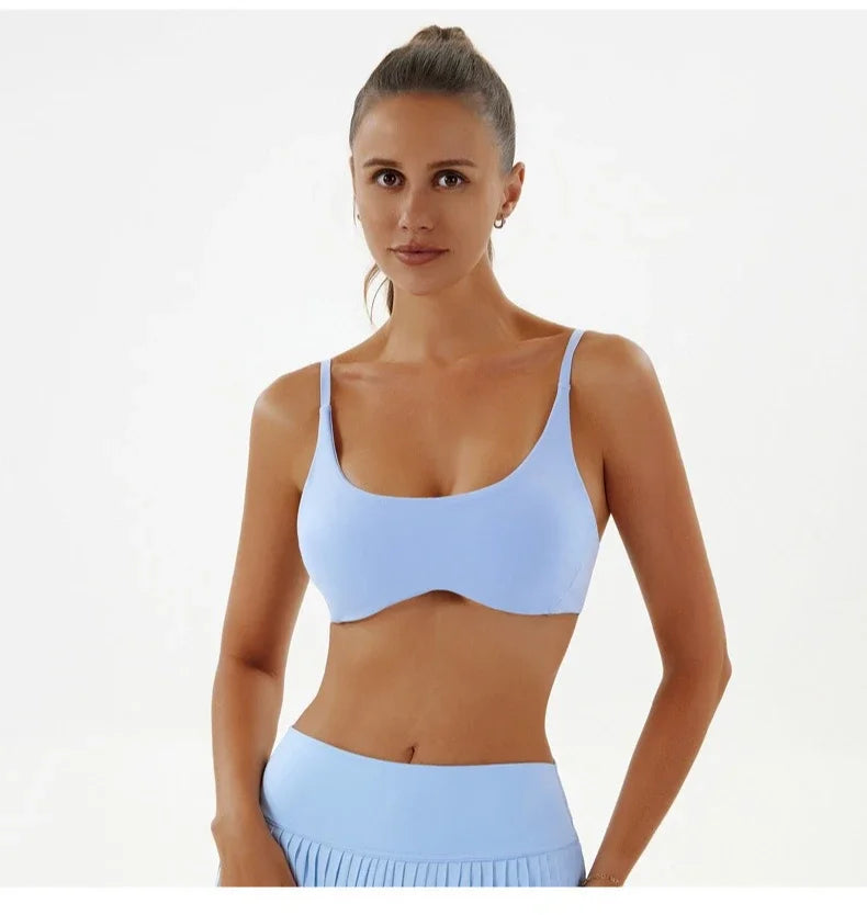 Woman wearing a light blue sports bra and leggings on a white background