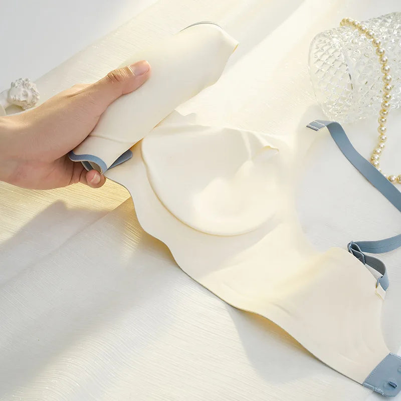 Hand holding a white spray bottle over a white fabric with a blue strap.