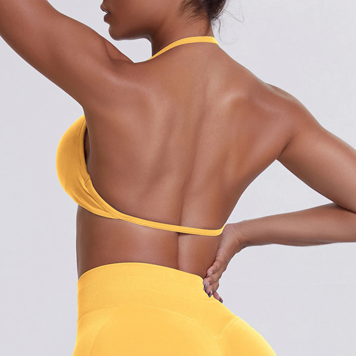 Person wearing a yellow bikini against a light gray background