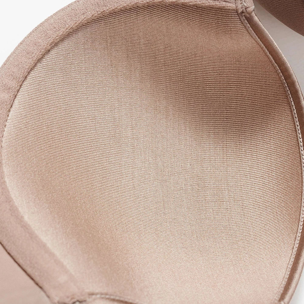 Close-up of a smooth, textured beige or nude-colored bra cup with fine ribbed fabric.